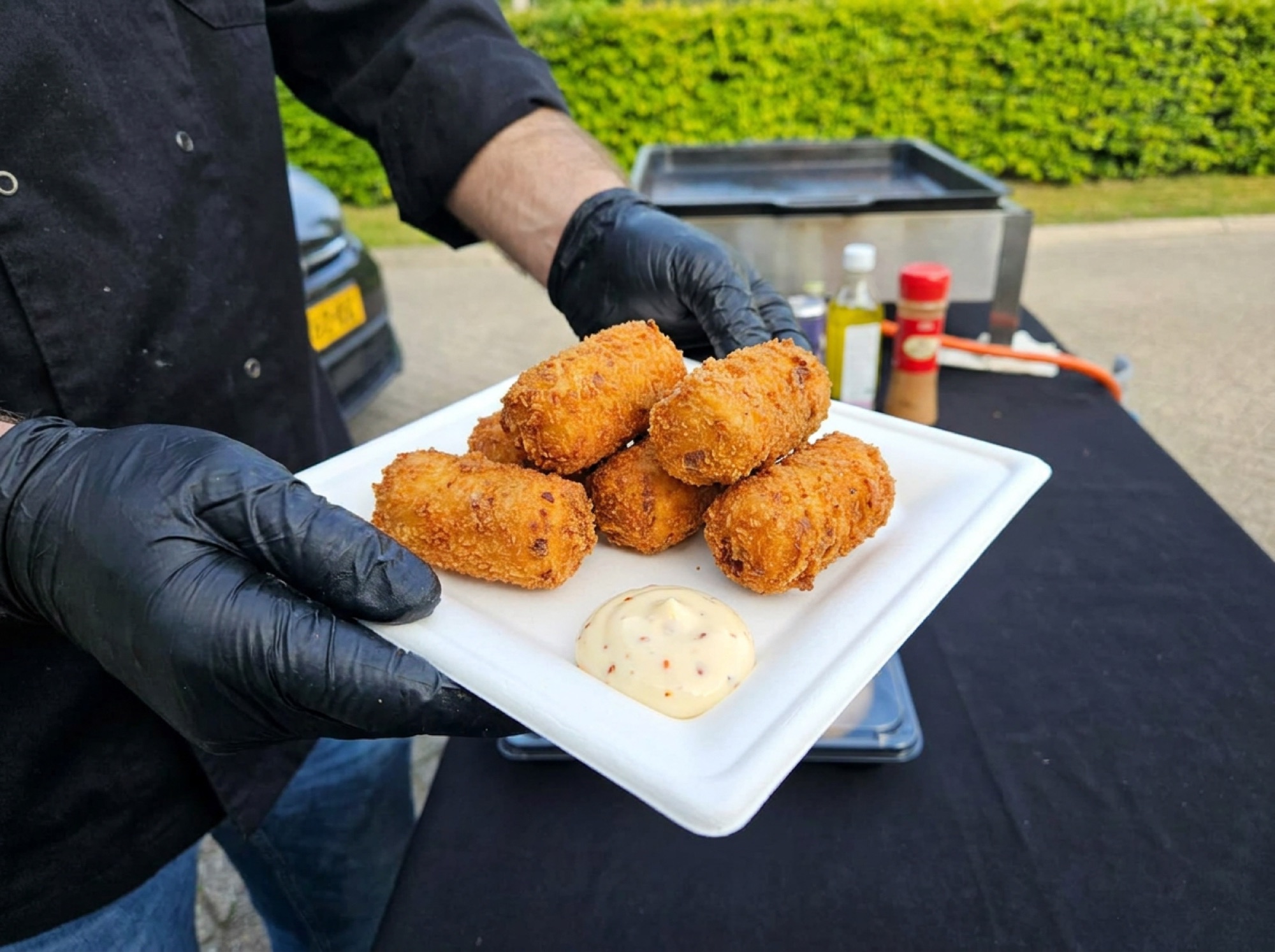 Iberico-hamkroketten op wit suikerrietbord met chili-mayonaise direct op het bord