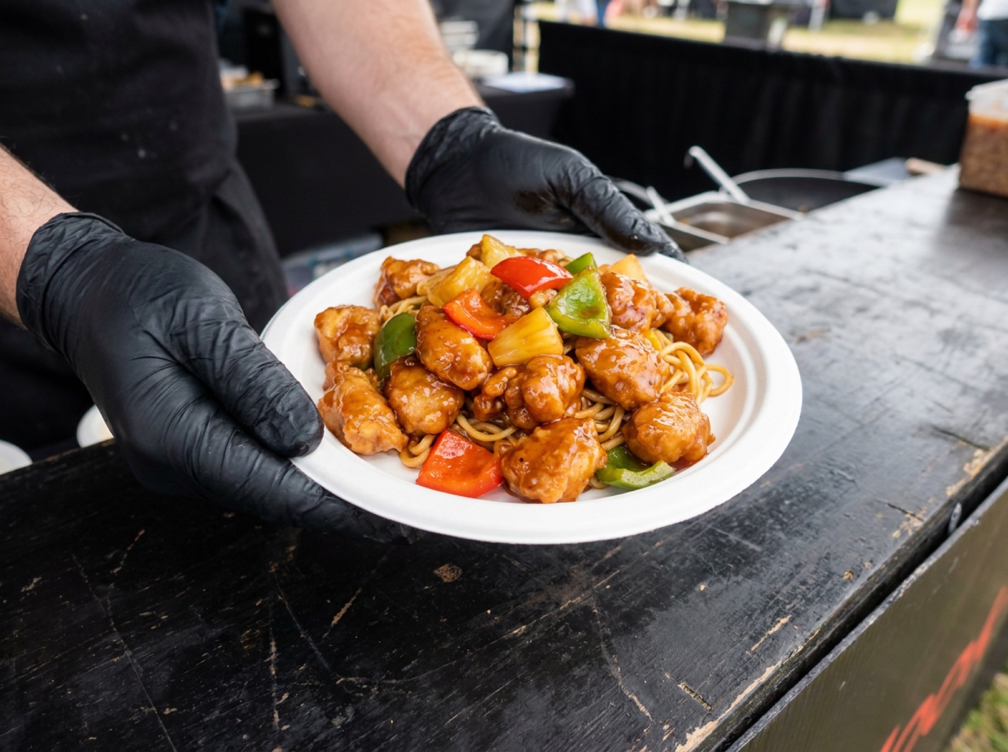 Thaise kip zoetzuur met noedels op wit suikerrietbord aan de cateringcounter